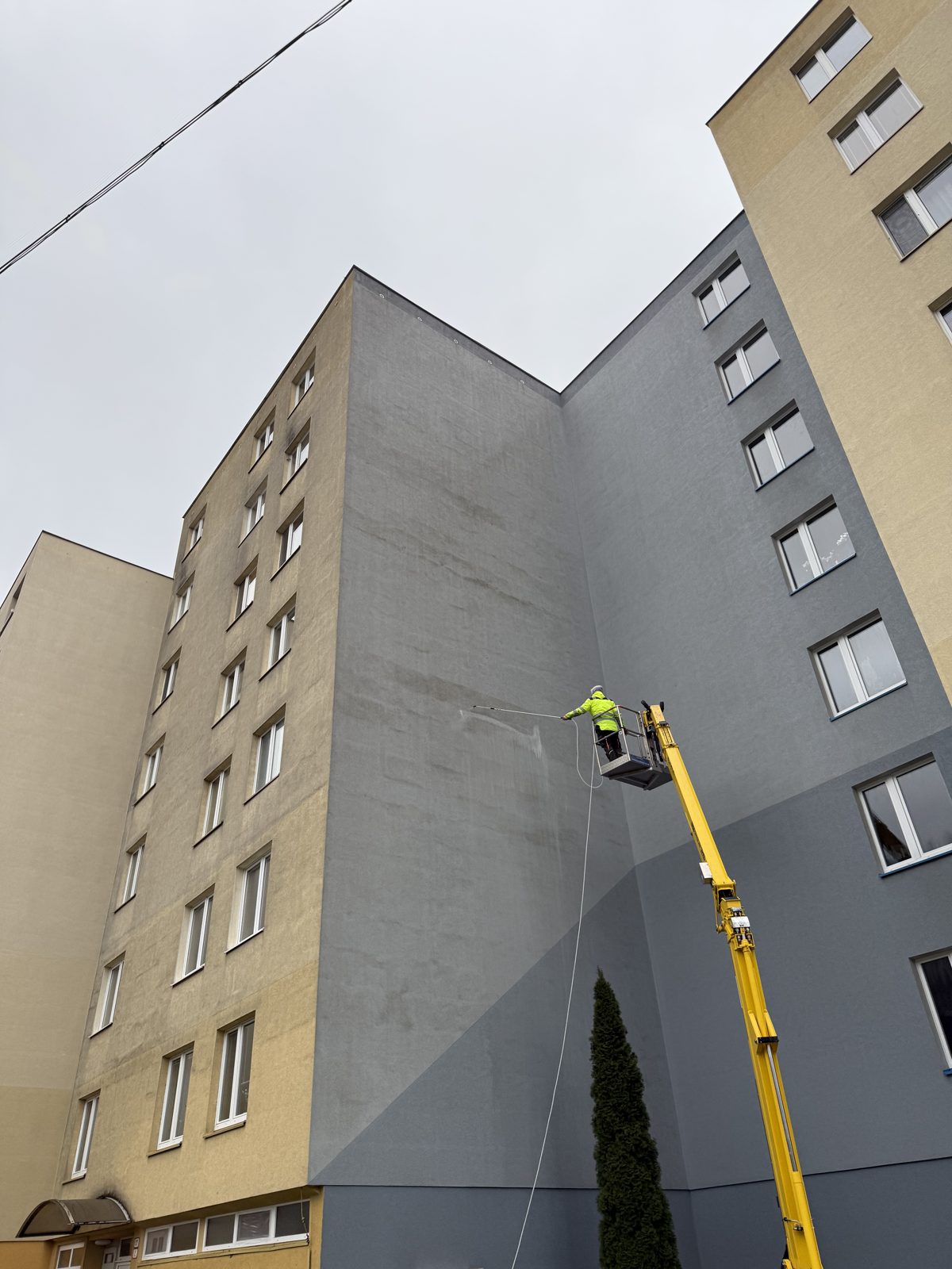 Umývanie fasády bytového domu z plošiny