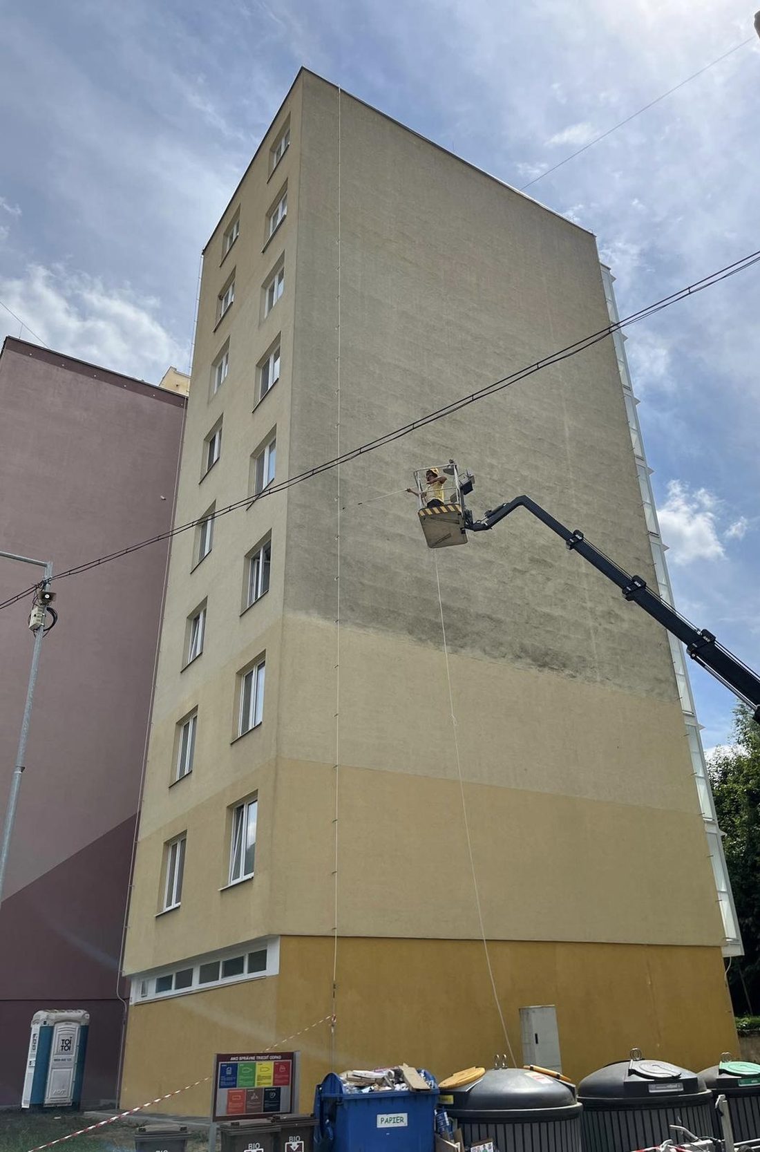 Technik EvoClean čistí fasádu bytového domu z plošiny
